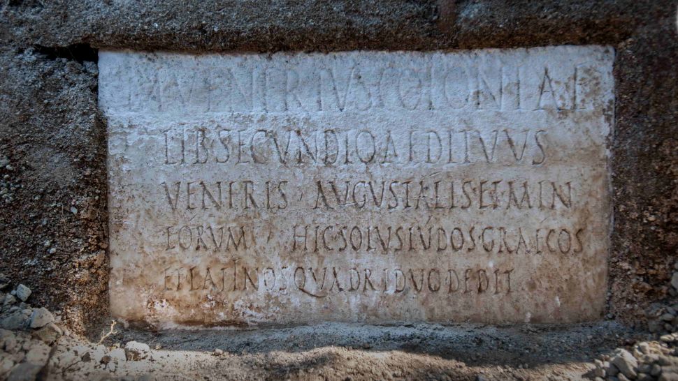 A inscrição no túmulo nomeia Marcus Venerius Secundio e diz que ele realizava quatro dias de apresentações em grego e latim como um sacerdote no culto imperial.